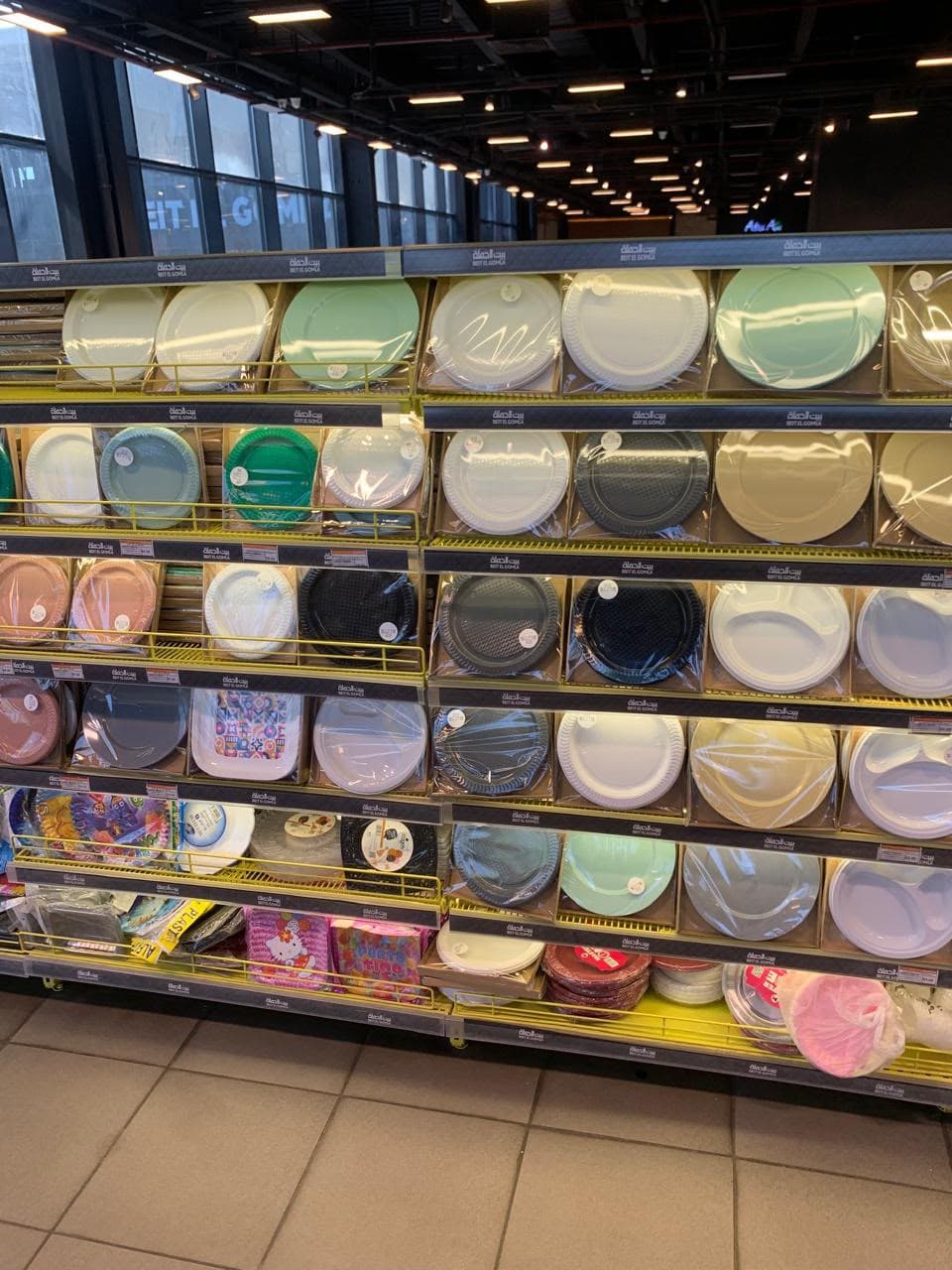 Colorful plastic plates displayed on a supermarket aisle